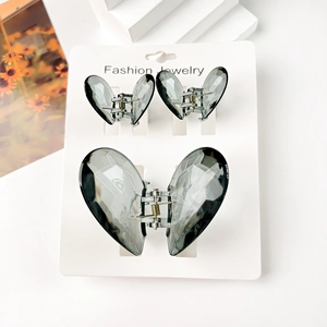 Detailed macro view of three translucent butterfly hair clips on a white jewelry card