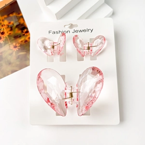 Detail of pink transparent heart hair clips set on display card with gold spring hinge