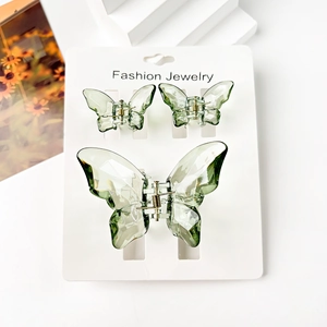 Three-piece green butterfly hair claw set with semi-transparent acrylic on white display card