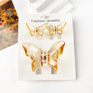 Three-piece butterfly hair claw set in amber translucent resin on display card