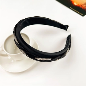 Detail of elegant black satin braided headband with sparkling rows of white rhinestones