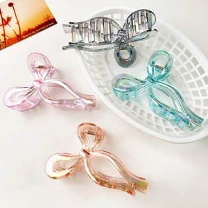 Detail of four colorful bow hair claws showing iridescent finish and secure teeth design