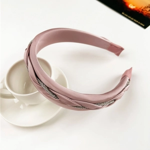 Detail of elegant woven lotus pink satin headband with sparkling rhinestones and twisted design