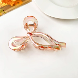 Close-up of translucent iridescent butterfly hair claw clip with metallic spring detail