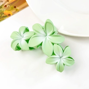 Vista dettagliata del fermaglio per capelli opaco verde con design a tre fiori
