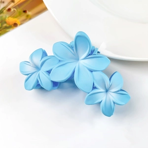 Dettaglio molletta per capelli azzurra opaca con design a tre fiori di frangipane