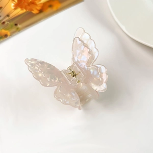 Detailed shot of a 3D butterfly hair claw with iridescent pearlescent finish and golden spring