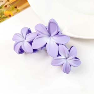 Dettaglio della grande pinza per capelli a fiore di frangipane viola opaco sfumato