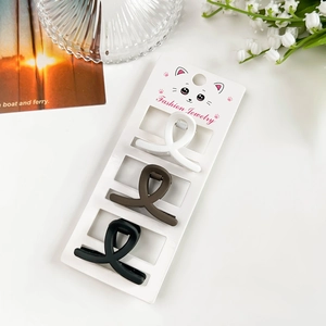 Lot de trois pinces à cheveux mates blanches, brunes et noires sur carte cadeau