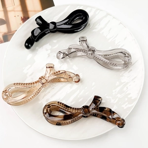Lot de quatre barrettes bananes en forme de nœud en noir, gris, doré et motif léopard