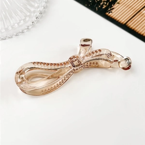 Détail de la pince banane nœud champagne avec décoration élégante de strass brillants