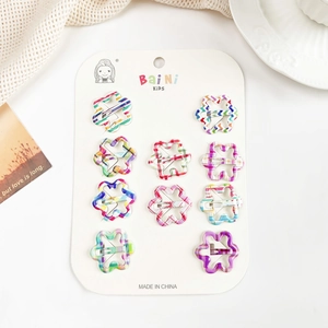 Gros plan de 10 barrettes fleurs colorées aux motifs géométriques sur carton