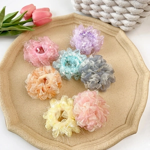 Set mit sieben farbenfrohen Organza-Haargummis in Pastelltönen auf einem Tablett