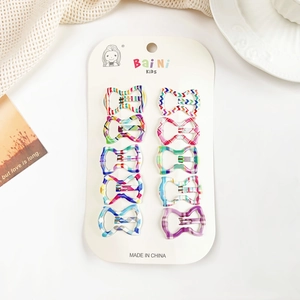 Gros plan de barrettes à cheveux colorées à motifs pour enfants sur carton blanc