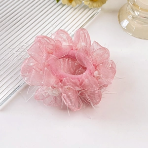 Detail eines rosa Organza-Haargummis mit Lagen-Mesh-Blüten und Federkantendesign
