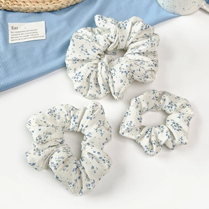Vue détaillée de trois chouchous à fleurs bleues avec plis en coton doux et coutures