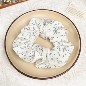 Détail d'un chouchou à fleurs bleues sur plat en céramique avec fond en dentelle élégant