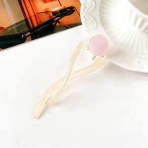 Dettaglio dell'elegante fermaglio a torsione crema con perla rosa delicata