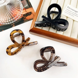 Classic knot hair claws in black and tortoiseshell finish on a vintage display