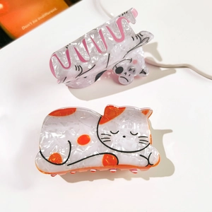 Detail of cute PVC cat hair claws with floral pearl texture and cartoon sleeping cat patterns