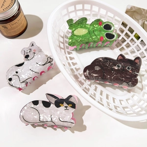 Cute PVC animal hair claws featuring cat and frog designs in a bright setting