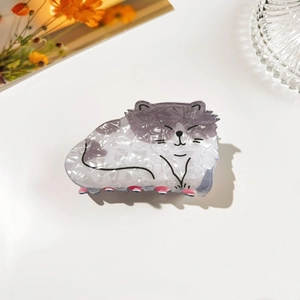 Detail of cute cat shaped hair claw clip with marble texture and pink accents