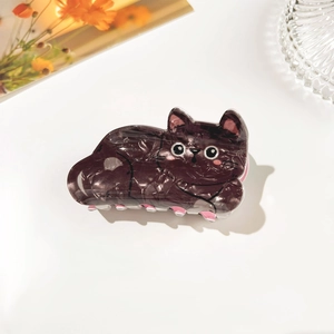 Detail of a cute cat-shaped hair claw clip with marble texture and pink grip teeth