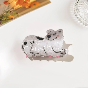 Detail of marble-textured puppy hair claw clip with pink teeth and cartoon outline