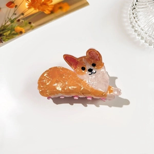 Close-up of a cute Corgi dog hair claw clip with orange glitter texture and pink teeth