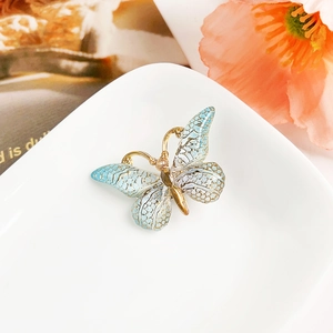 Gros plan sur une pince à cheveux papillon bleu dégradé avec dorure et cristal