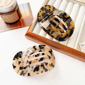 Elegant oval cutout hair claws in tortoise shell acetate for stylish ponytail styling