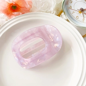 Close-up of lilac marble acetate hair claw clip on white porcelain plate decor