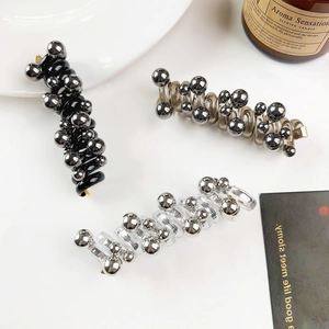 Detail showing spiral hair ties with metallic beads in black, champagne, and silver