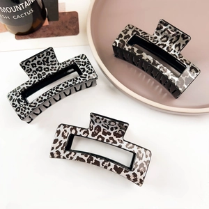 Detailed view of three square hollow hair claws with leopard print animal patterns
