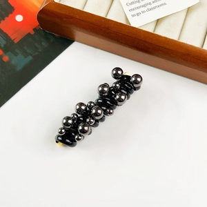 Detail of spiral telephone wire hair ring with glossy metallic beads and high elasticity