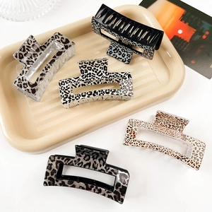 Close-up of five large geometric leopard print hair claws with various animal textures