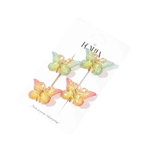 Lot de quatre barrettes papillon dégradées avec bords dorés sur carte de support