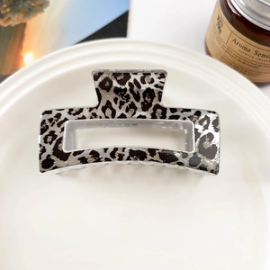 Detailed view of square leopard print claw clip made of premium acetate on a ceramic tray