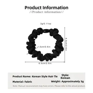 Detail view of a black satin scrunchie with plastic buckle showing size and 3g weight