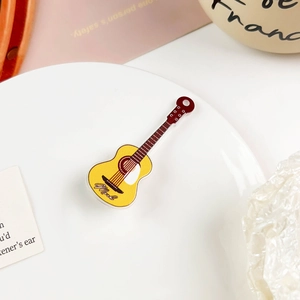 Nahaufnahme einer kreativen Mini-Gitarre Haarspange im Y2K-Stil auf einem weißen Tablett