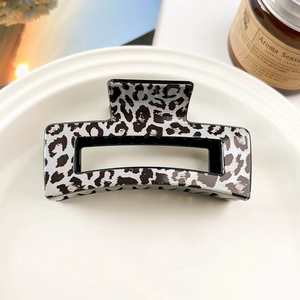 Detail of a rectangular leopard print hair claw clip on a white ceramic plate