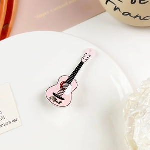 Detailaufnahme eines rosa Acryl-Gitarrenanhängers mit einer Music-Gravur in Schreibschrift