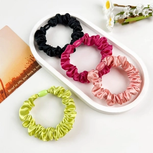 Set of four satin scrunchies in pink and green with matching plastic buckle connectors