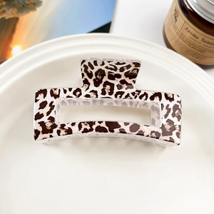 Detailed macro view of a stylish leopard print rectangular hair claw clip on a tray