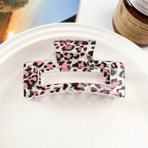 Detailed view of square leopard print hair claw clip in a white ceramic dish