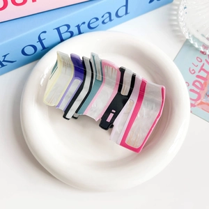 Macro detail of book-shaped acrylic hair claw clip with colorful marble textures