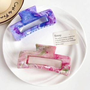 Macro detail of square acetate hair claw clips with marble texture in purple and pink tones