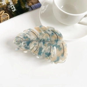 Vue détaillée de la pince à cheveux en acétate avec motif feuille et texture marbrée