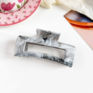 Detailed view of large rectangular hair claw clip with black and white marble pattern texture