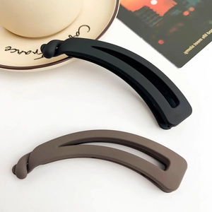Gros plan de pinces à cheveux banane noir mat et moka avec un design évidé